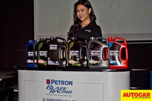 Model posing with line of petrol engine oil range at the Petron Malaysia HTP Engine Oil launch